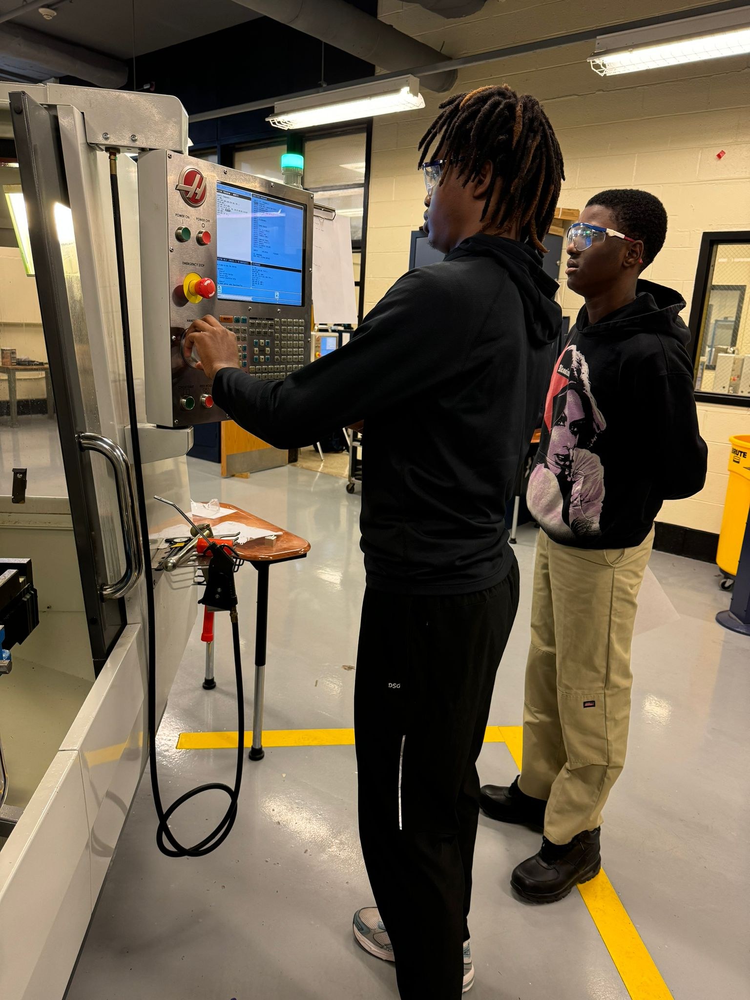 UYRS students operating a CNC machine